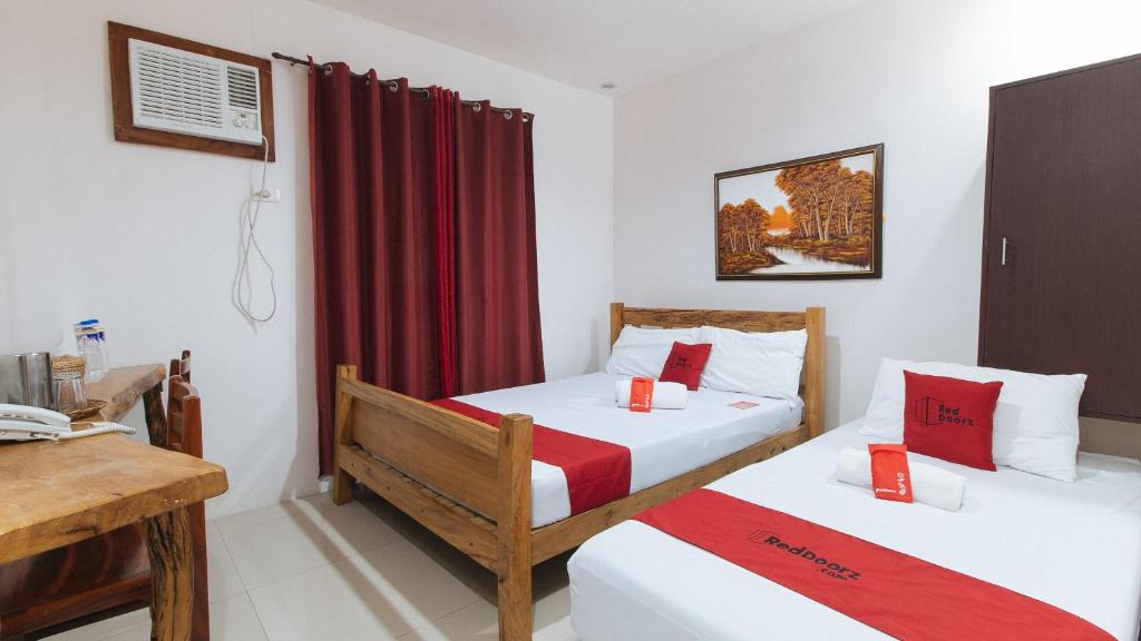 Postel nebo postele na pokoji v ubytování RedDoorz Plus @ Jollydays Hotel Nueva Ecija
