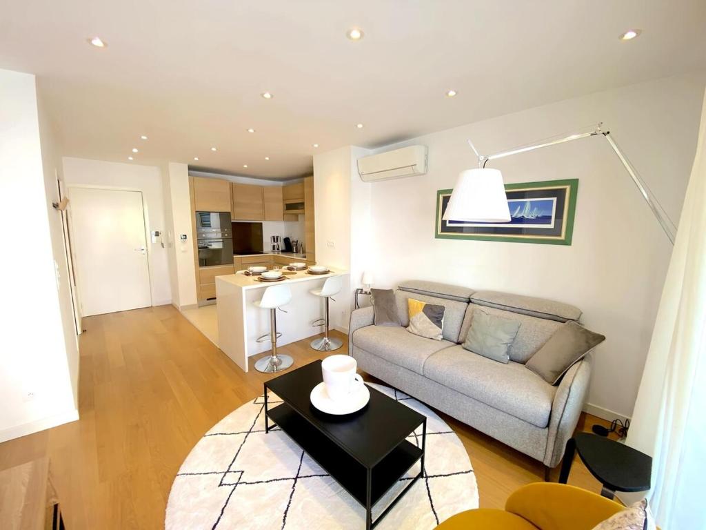 un salon avec un canapé et une table dans l'établissement T2 Neuf centre ville Sanary avec garage, à Sanary-sur-Mer