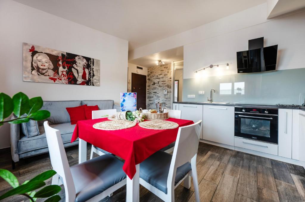 une cuisine et une salle à manger avec une table et des chaises rouges dans l'établissement Perugia Moxy TE&AM Old Town Parking gratis, à Cracovie
