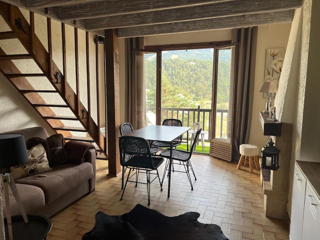 un salon avec une table et un canapé dans l'établissement Duplex Vue Montagne au Calme, à Gréolières