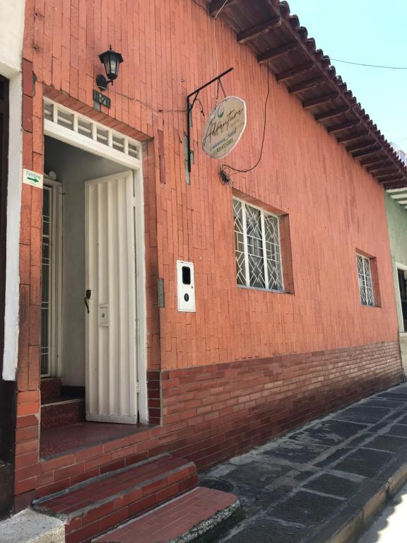 a red brick building with a white door at ADVENTURE Hostel in San Gil
