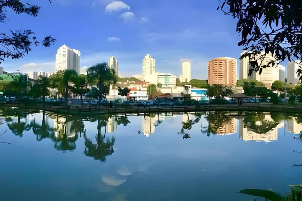 a city skyline with a reflection in a lake at 0001 - Pousada HG quarto home office, duplo in Vila Gopoúva