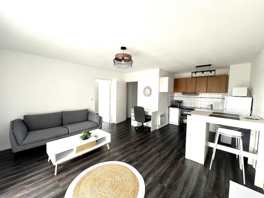 エオレにあるAigues Marines - Appartement spacieux avec parking et terrasseのソファとキッチンのあるリビングルーム