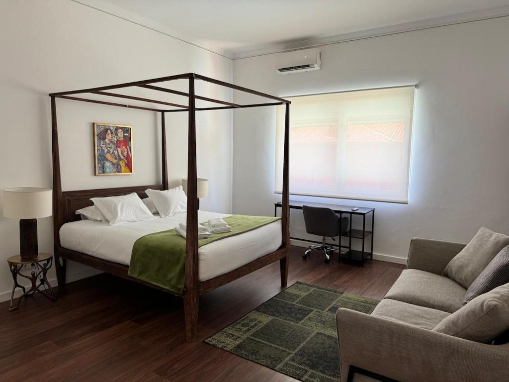 a bedroom with a canopy bed and a couch at Estoril 17 in Estoril