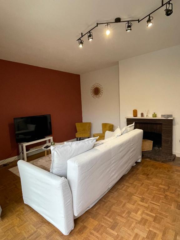 un salon avec des canapés blancs et une télévision dans l'établissement Maison des Rêves de Loire, à Saint-Aignan