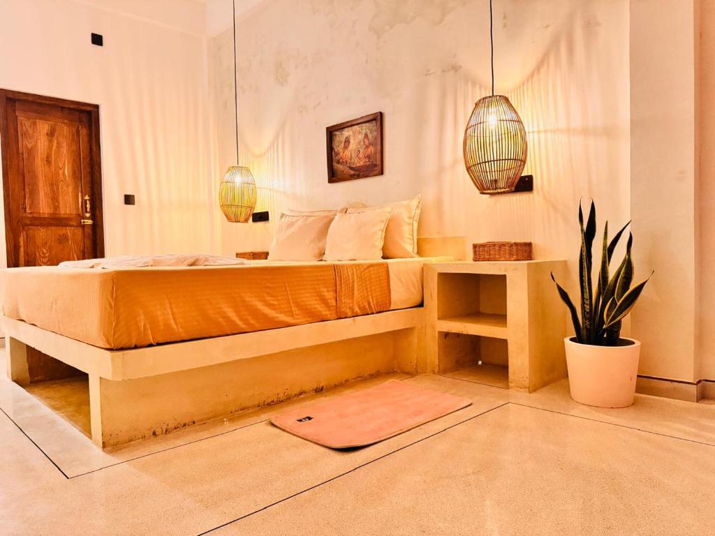 a bedroom with a bed and a table with a plant at San-Khara in Ahangama