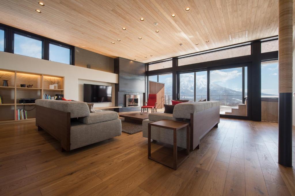 a living room with a couch and chairs and a television at Kazahana 風華 in Kutchan