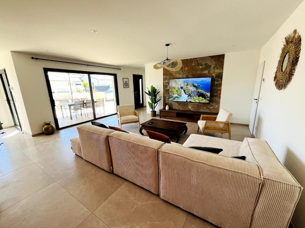 a living room with a couch and a table at Villa exotique avec piscine - Dolce Rhôna in Charmes-sur-Rhône