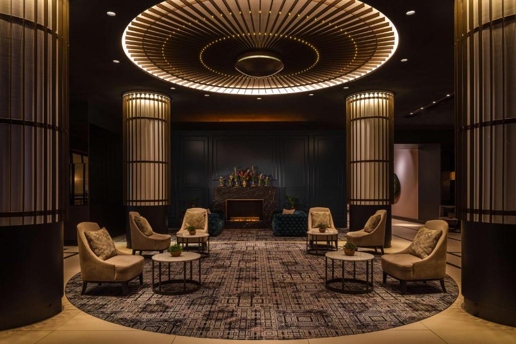 a large lobby with chairs and a large chandelier at Anantara Grand Hotel Krasnapolsky Amsterdam in Amsterdam