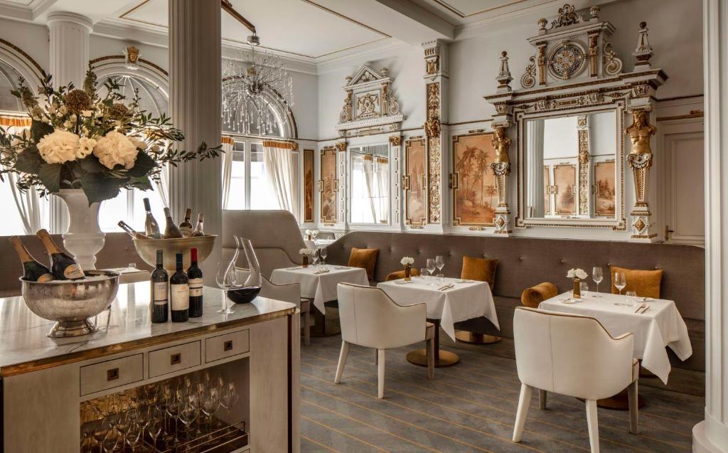 a restaurant with tables and chairs and a fireplace at Anantara Grand Hotel Krasnapolsky Amsterdam in Amsterdam