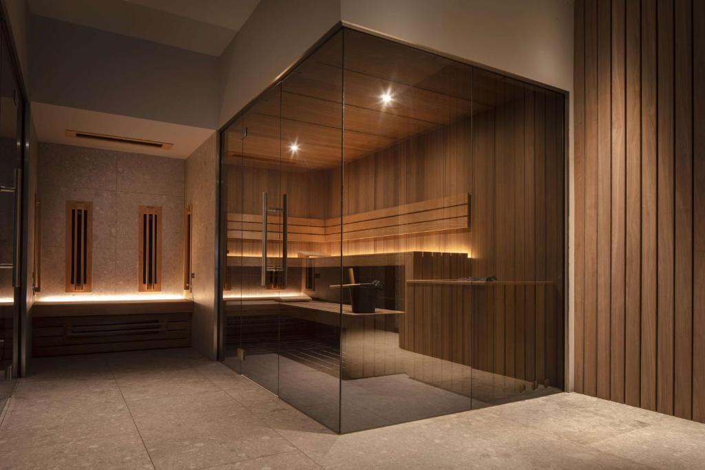a bathroom with a large glass wall with a sink at Anantara Grand Hotel Krasnapolsky Amsterdam in Amsterdam