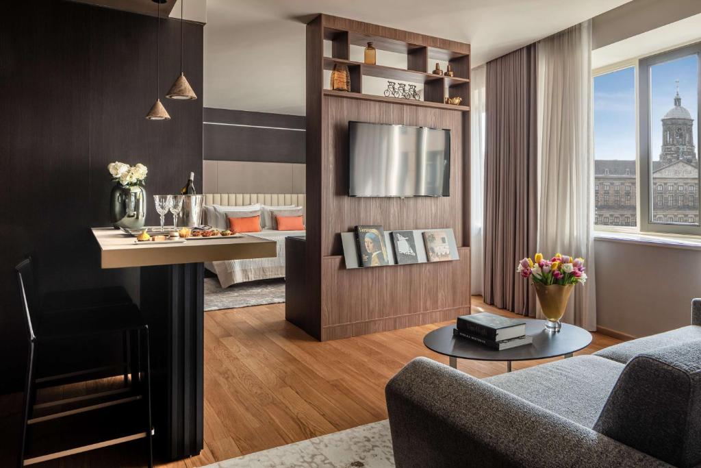 a living room with a couch and a table at Anantara Grand Hotel Krasnapolsky Amsterdam in Amsterdam