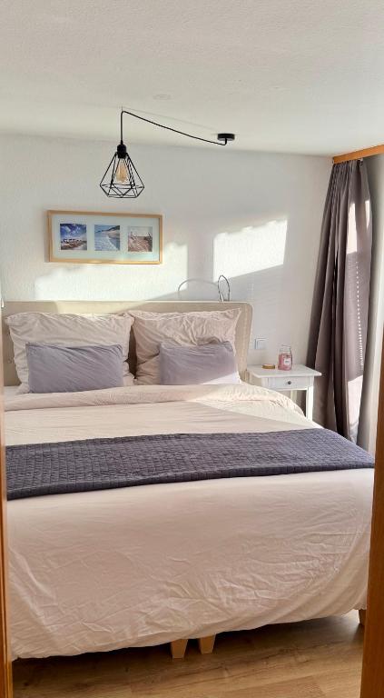 a bedroom with a large bed with white sheets at Pension Schmidt - Schwarzwaldnest - voll ausgestattetes Apartment in Häusern