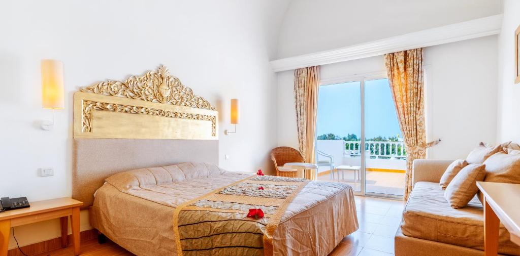 a bedroom with a bed and a living room at Iris Hotel & Thalasso in Taguermess