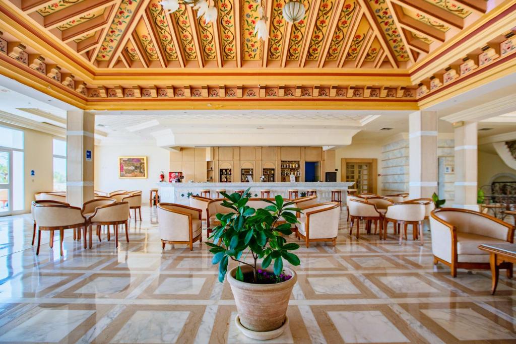 a large room with chairs and a bar in a building at Iris Hotel & Thalasso in Taguermess