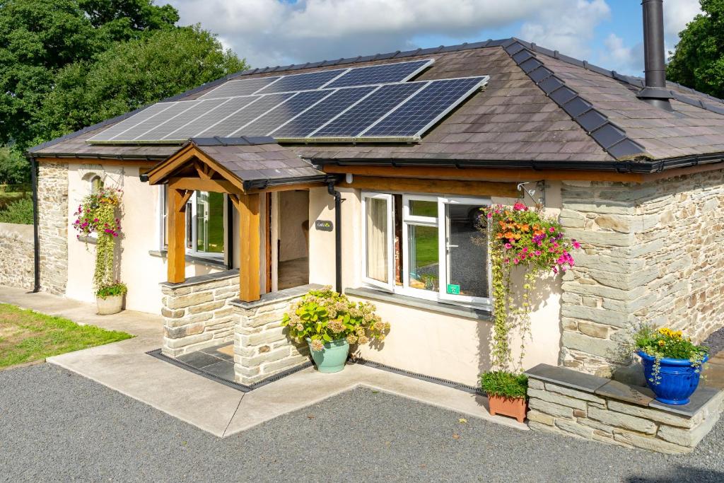 a small house with solar panels on the roof at Cothi Cottage in Cardigan