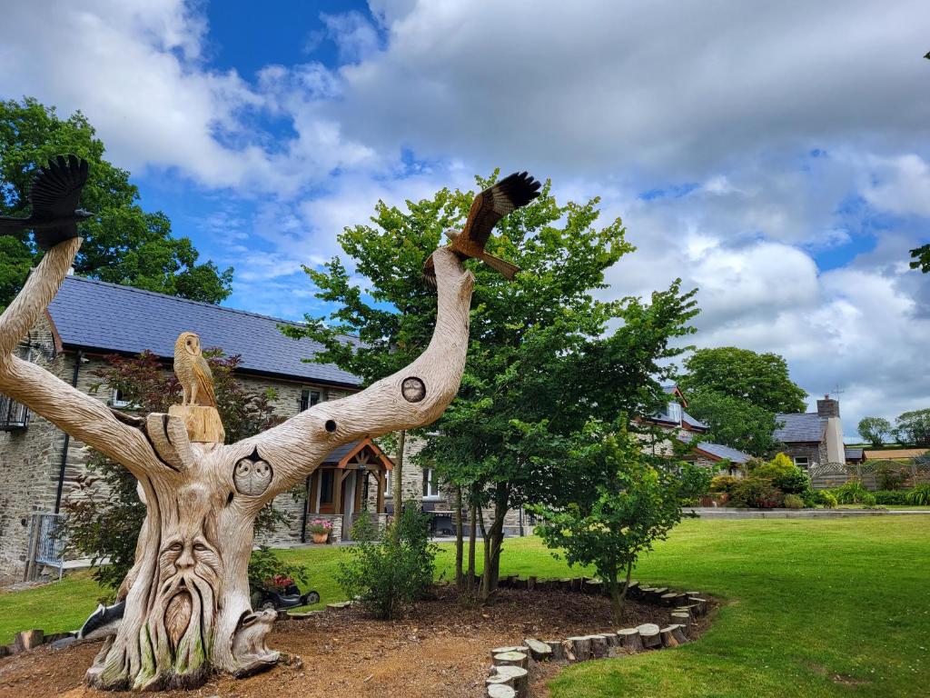 un arbre avec deux oiseaux assis au-dessus dans l'établissement Teifi Cottage, à Cardigan