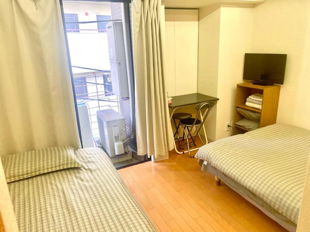 a hotel room with two beds and a window at Shinjuku West Park Inn Hanabi House in Tokyo