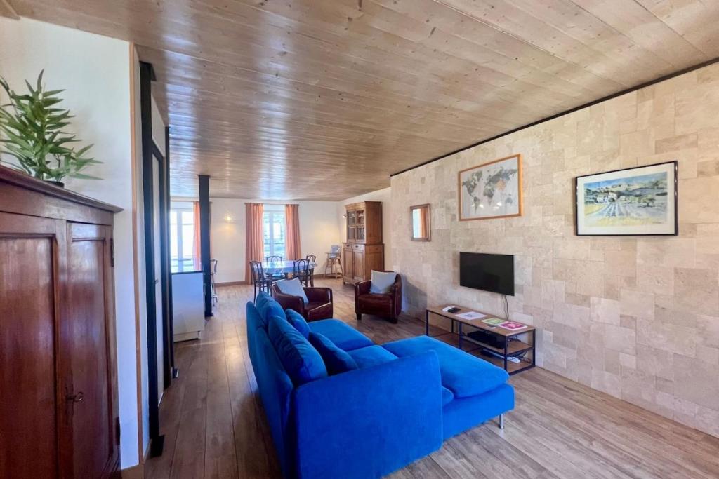 un salon avec un canapé bleu et une télévision dans l'établissement Casa Montcalm - T2 -Clim -Proche GareCentre Brive, à Brive-la-Gaillarde