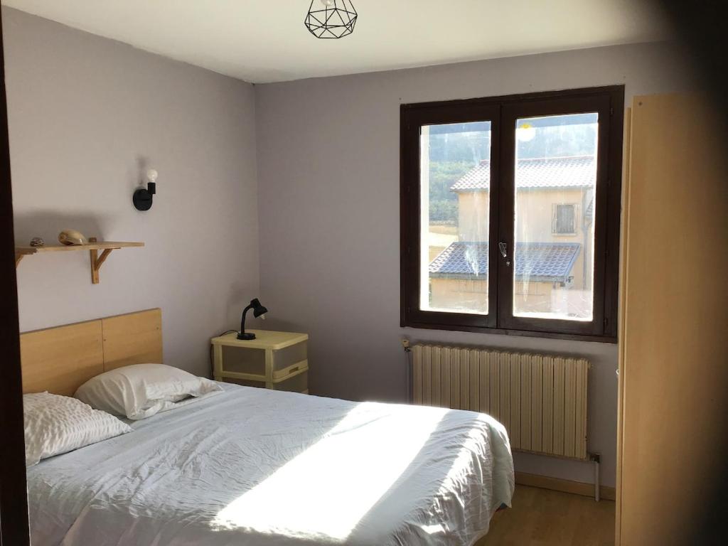a bedroom with a bed and a window at Apartment in cozy house with terrace in Aspres-sur-Buëch