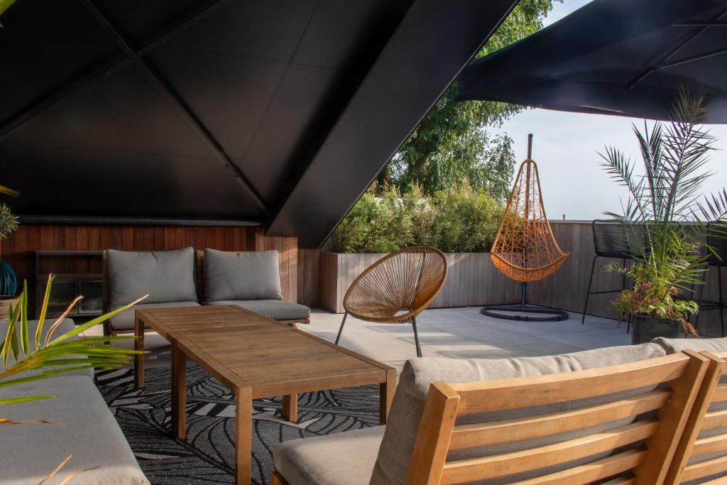 a patio with a hammock and a table and chairs at Enjoy Heaven in Schellinkhout