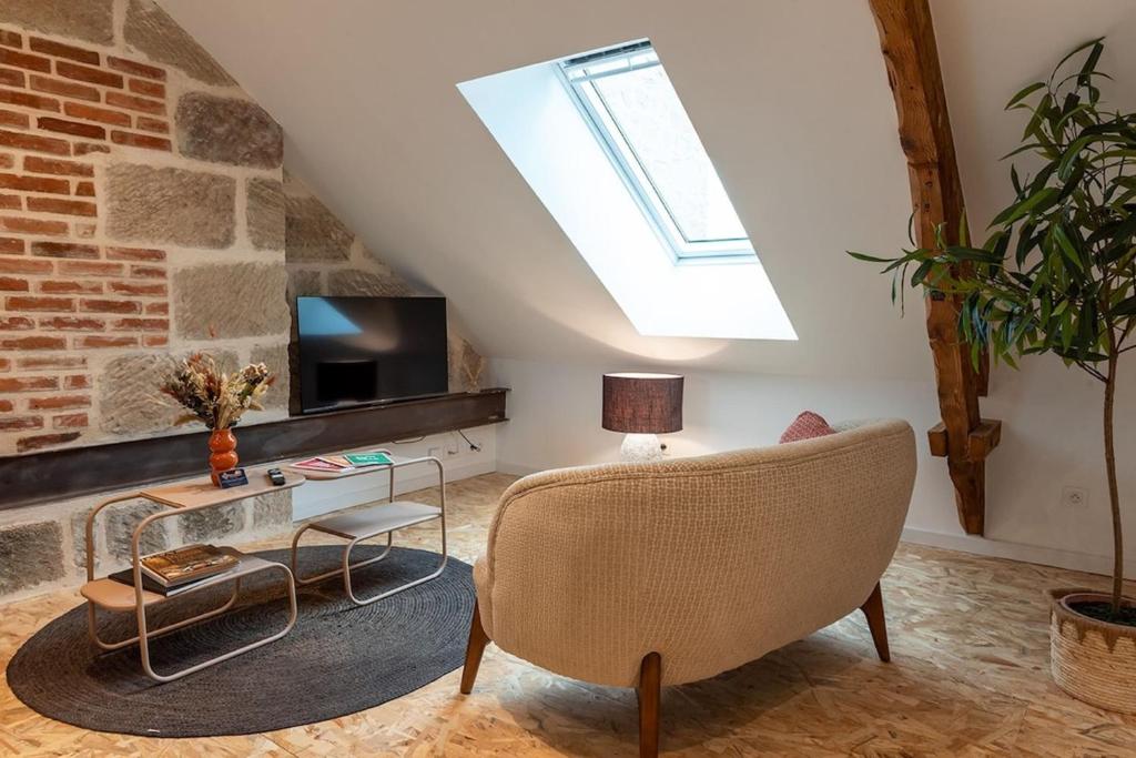 - un salon avec une lucarne et un canapé dans l'établissement Casa Roche - T2 -Clim - Proche Centre & Gare Brive, à Brive-la-Gaillarde