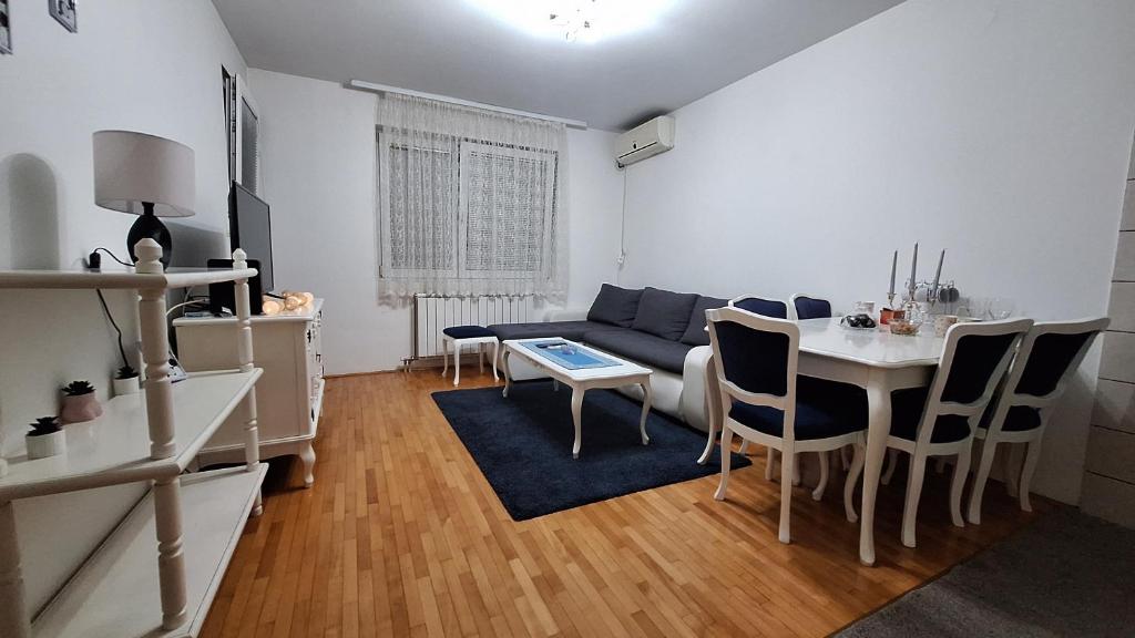 a living room with a blue couch and a table at Apartman Park in Šabac
