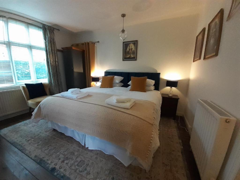 a bedroom with a large bed with towels on it at Grail Cottage in Glastonbury