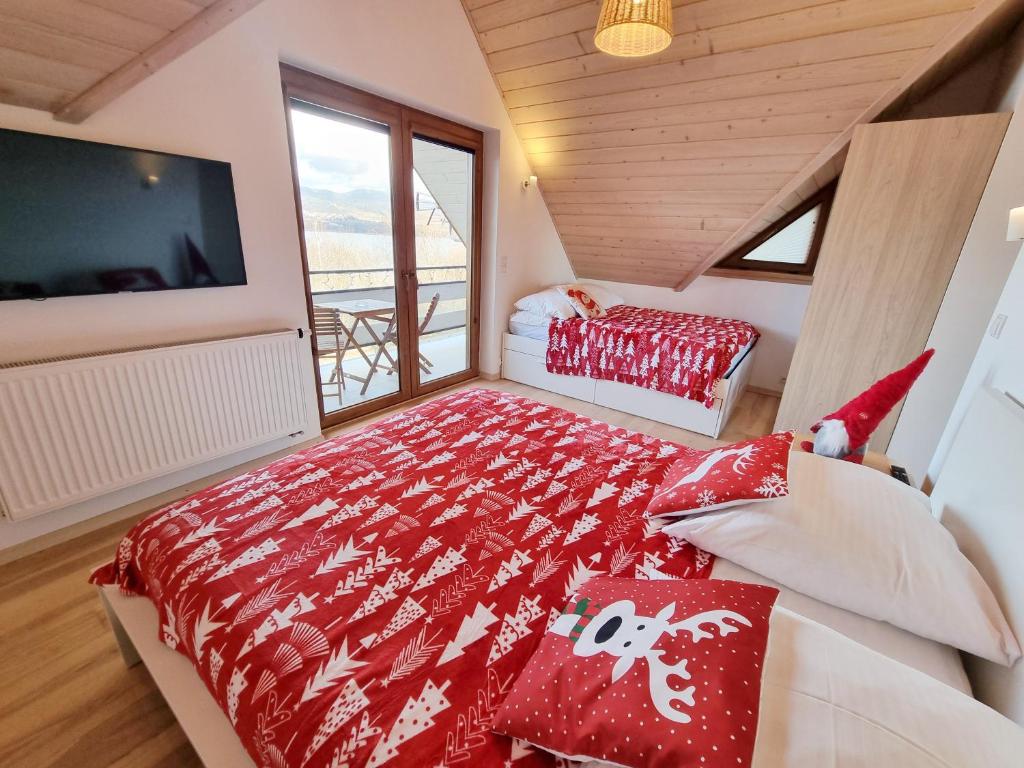 a bedroom with a bed and a large window at DOMEK Z KOMINKIEM Z WIDOKIEM na Jezioro Czorsztyńskie in Frydman