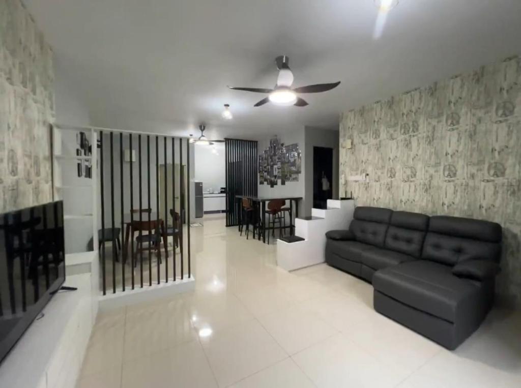 a living room with a couch and a dining room at Simply Staycation Palm Garden in Lahad Datu