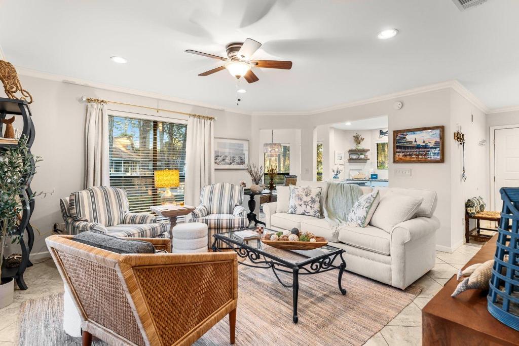 ein Wohnzimmer mit Möbeln und einem Deckenventilator in der Unterkunft Fairways 228 &quot;Bluegrass Bungalow&quot; in Destin