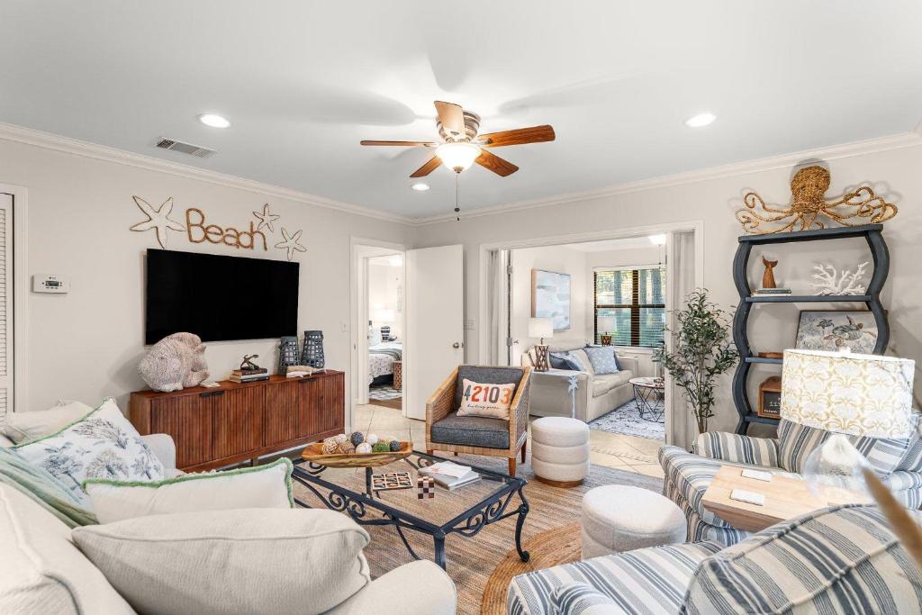 ein Wohnzimmer mit weißen Möbeln und einem Flachbild-TV in der Unterkunft Fairways 228 &quot;Bluegrass Bungalow&quot; in Destin