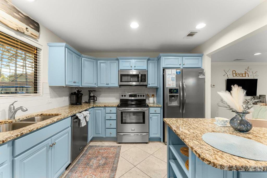 eine blaue Küche mit Küchengeräten aus Edelstahl und blauen Schränken in der Unterkunft Fairways 228 &quot;Bluegrass Bungalow&quot; in Destin