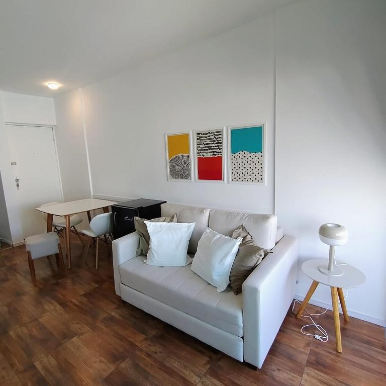 a living room with a white couch and a table at Lindo Flat Terraço Garagem Metrô Liberdade Paraíso in Sao Paulo