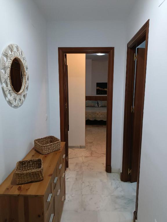 Habitación con tocador de madera y espejo. en Apartamento Al Sur del Sur, en Sanlúcar de Barrameda