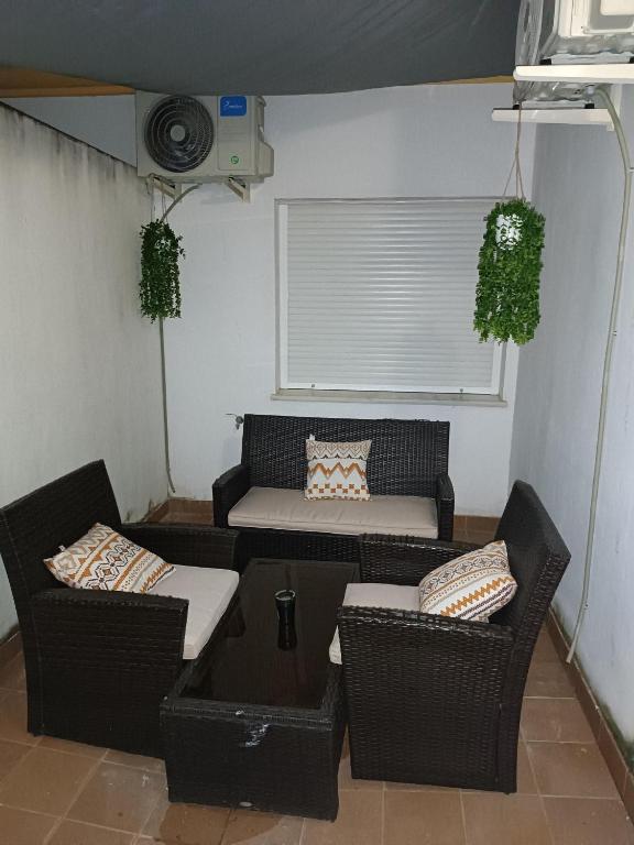 Una pequeña sala de estar con dos sillas y un sofá. en Apartamento Al Sur del Sur, en Sanlúcar de Barrameda
