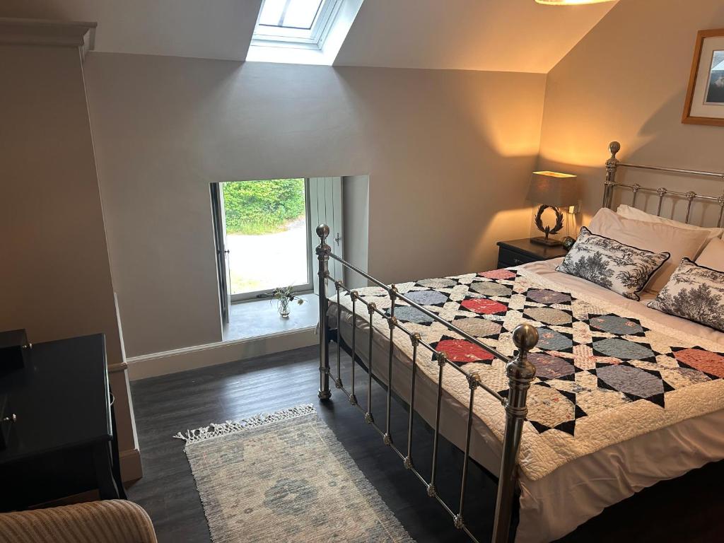 a bedroom with a bed with a quilt on it at Aldernaig Mill in Invergarry