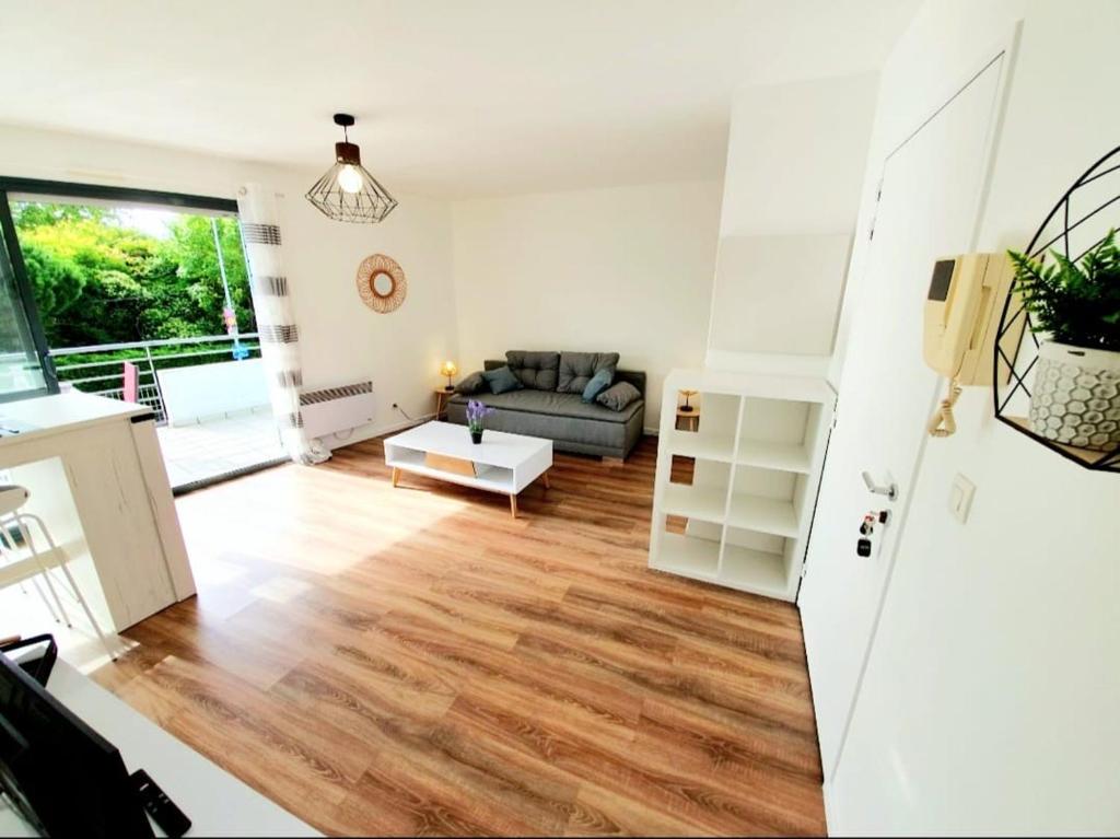 un salon avec un canapé et une table dans l'établissement La Frégate studio spacieux avec terrasse, à La Rochelle