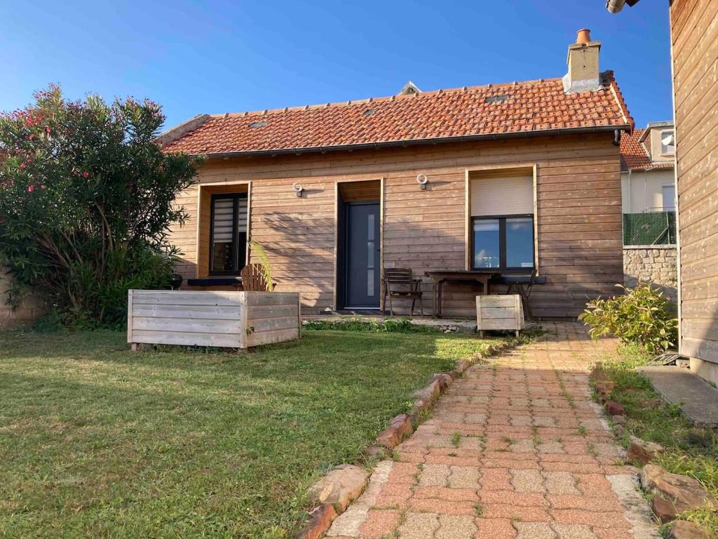 a small brick house with a grass yard at Maisonnette Individuelle in Carpiquet