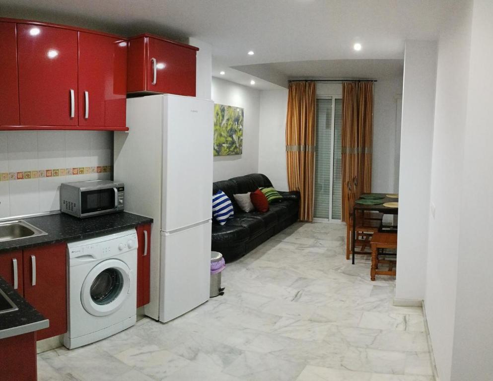 cocina y sala de estar con armarios rojos en Apartamento Al Sur del Sur, en Sanlúcar de Barrameda