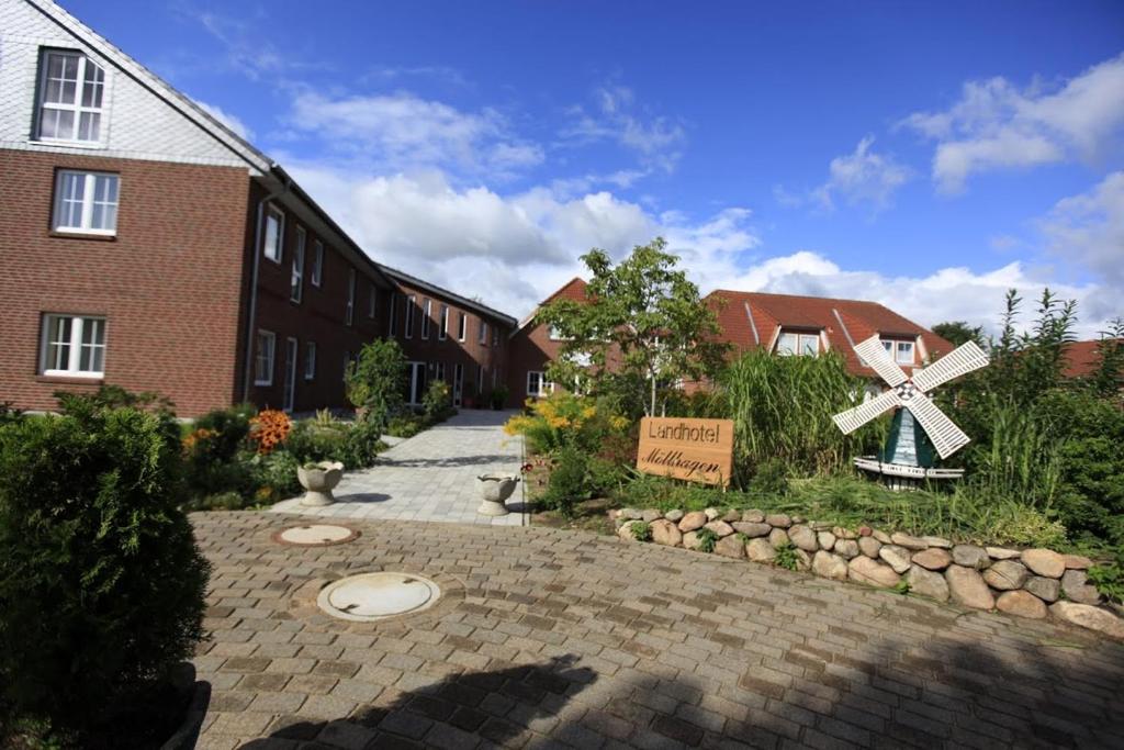 a brick building with a sign in front of it at Landhotel Möllhagen in Schülp