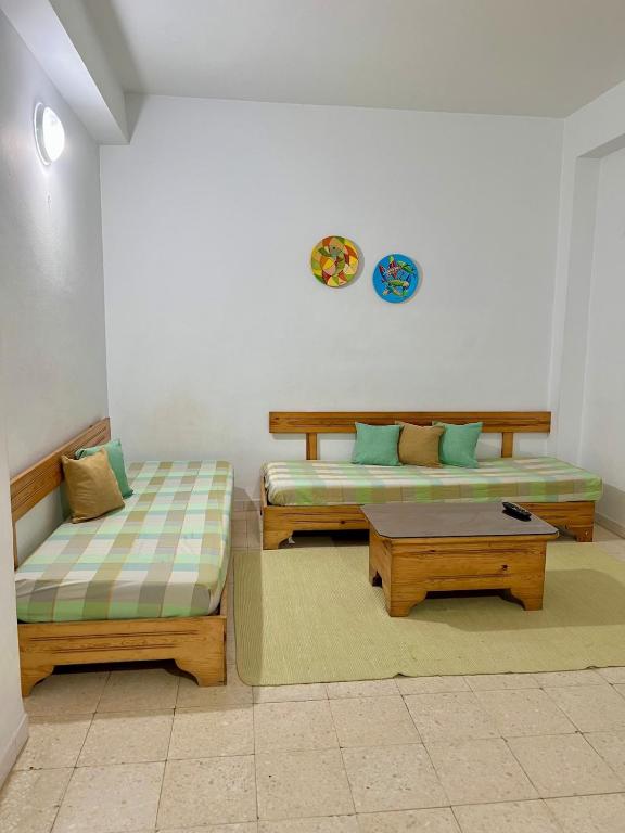 a living room with two beds and a table at Family-Friendly Studio in Mahdia