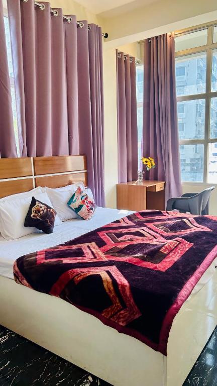 a bedroom with a large bed with purple curtains at Himaksh Homestay in Varanasi