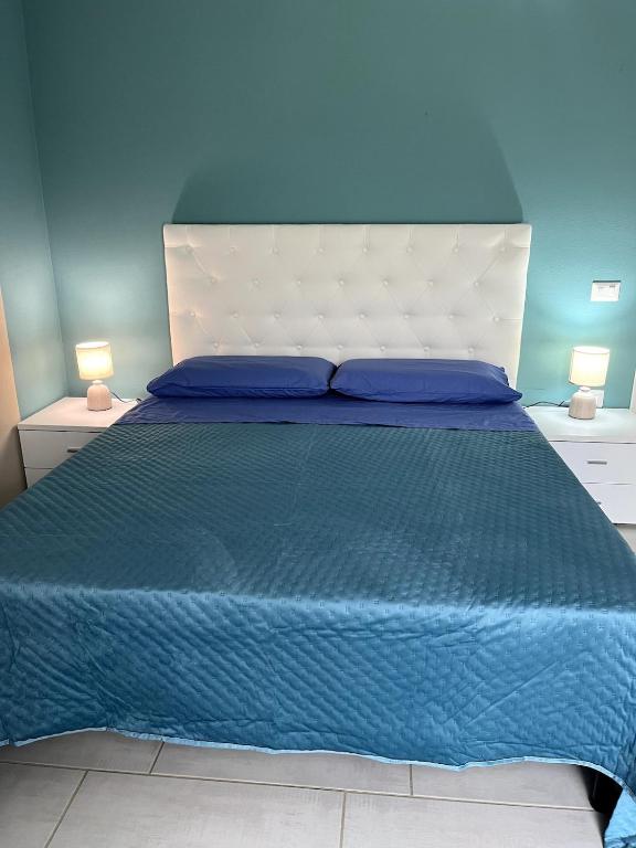AnnunziataVILLA AUREA Apartment in Castiadas的一间蓝色的卧室，配有一张大床和蓝色的墙壁