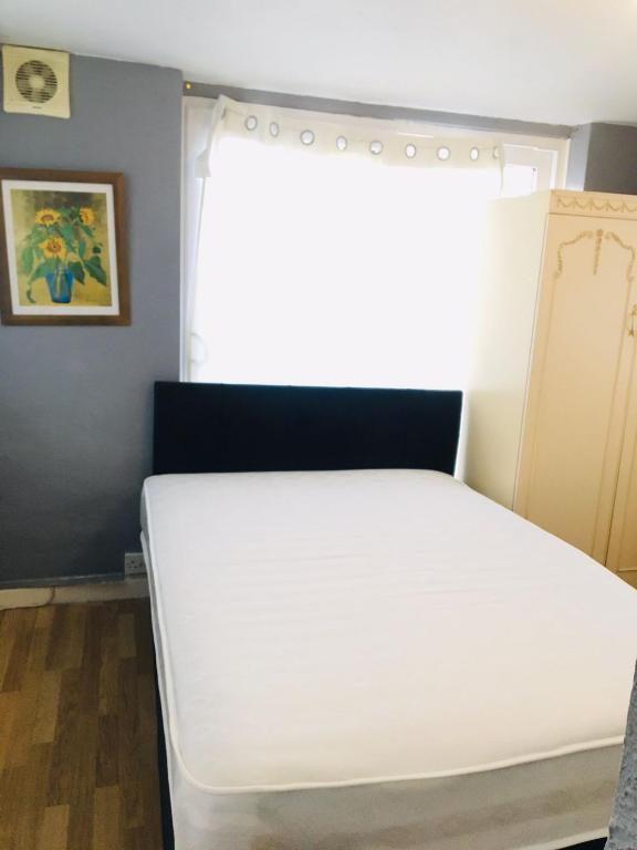 a white bed in a room with a window at Goldicroft House Road in Wednesbury