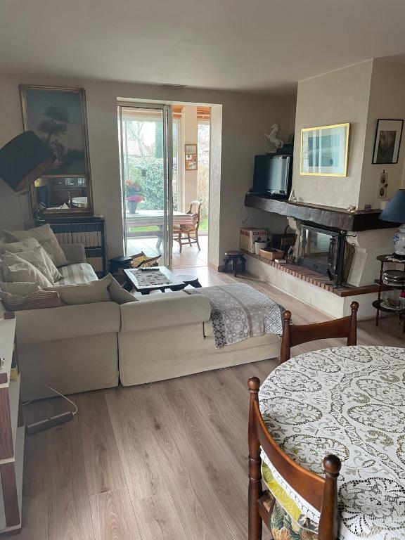 un salon avec un canapé et un lit dans l'établissement Maison Vivaldi pour 6 pers Andernos les Bains, à Andernos-les-Bains