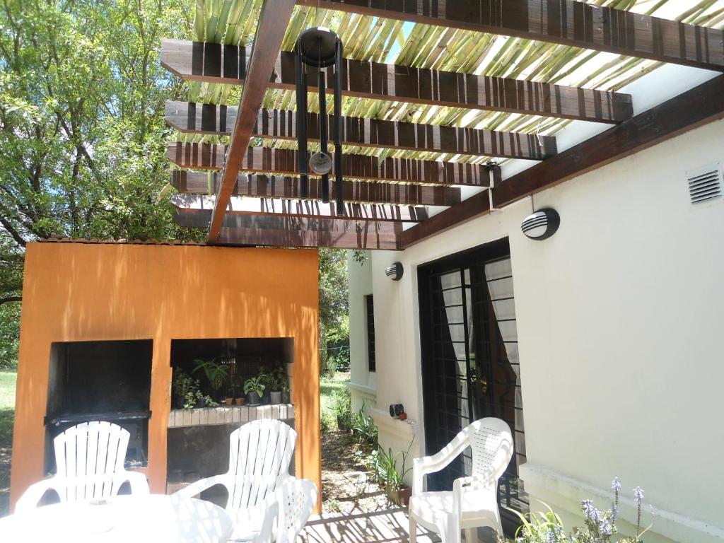un patio con sillas blancas y un piano en Arcadia, en Merlo