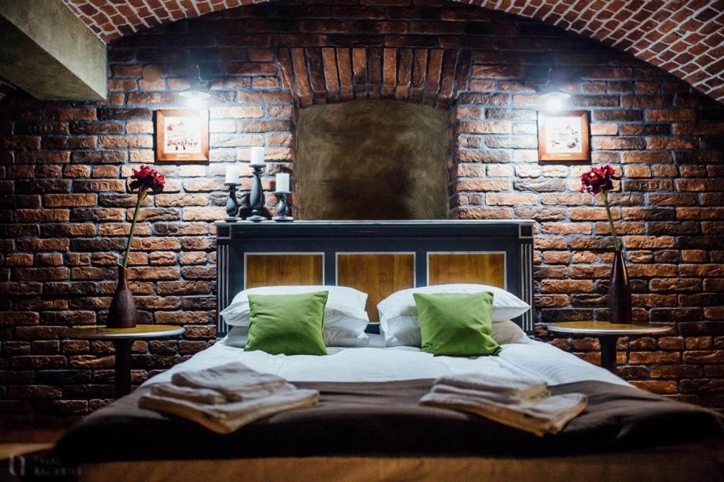 a bedroom with a bed in a brick wall at Apartament 7 Chernivtsi in Chernivtsi