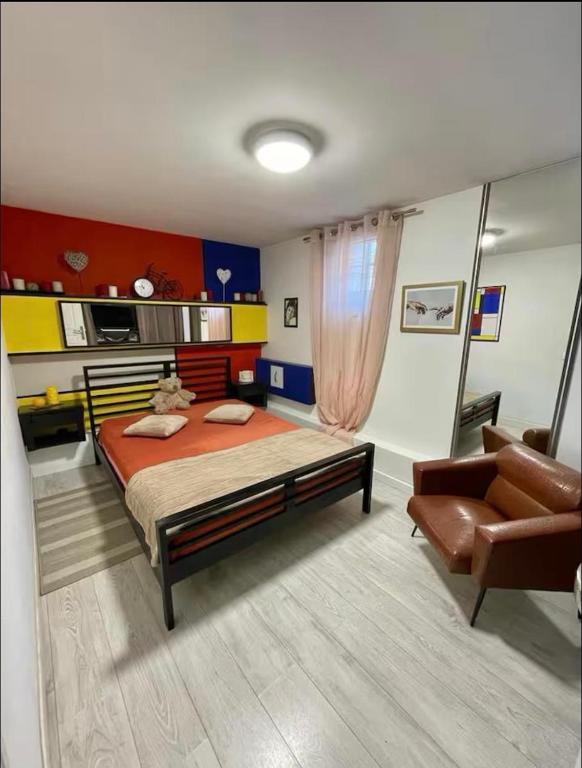 une chambre avec un lit, un canapé et une chaise dans l'établissement Chambre à 10 min de Paris, à Argenteuil