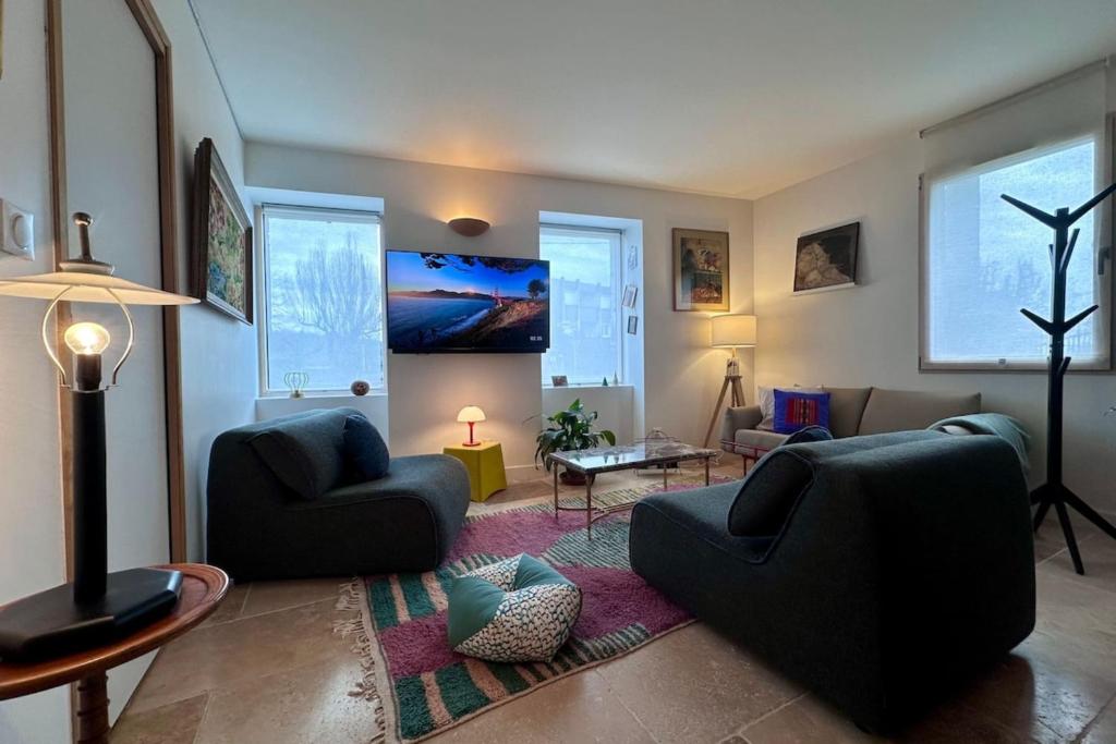 un salon avec deux chaises et une télévision dans l'établissement Maison de Marie - T2 ClimTerrasse - Meyssac Bourg, à Meyssac